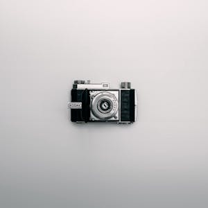 A classic Kodak camera displayed centrally on a minimalist white background.